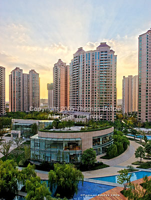 Shot as a high dynamic range image (HDR), during a rare sunset in Shanghai, the shot combines different exposures to show the unusual sky with lots of detail in the clubhouse and water. 
The living compound at the Western end of Changning district is typical for Shanghai's wealthier people, with several high rises encircling playgrounds, indoor and outdoor pools, tennis courts, golf driving range and clubhouse.
The HDR technique allows us to show the scene like the human eye would perceive it, extending the dynamic range upwards and downwards by two stops each.
