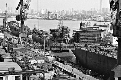 The old shipyards along the Huangpu river are being dismantled, giving way to the Expo 2010. Most shipyards have been moved to the Yellow River, where land is cheaper and in ample supply. In this image, a massive tanker is floating next to smaller vessels in the docks, while material is piled high on shore.