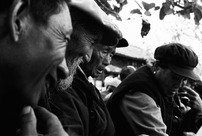 Playing a game of cards on the city square, old timers ignore the tourists around them and play for stakes.