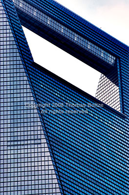 The World Financial Center is (for now) the tallest building in Shanghai. Shaped like an oversized bottle opener, the viewing platform on top provides an amazing view of Shanghai. 
This shot of the top end's facade shows its intricate class work in a most abstract fashion. 