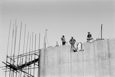 High atop one of the many pillars holding up the maglev, three workers look out over the construction site near Shanghai.

They invited my up, so I climbed the ramshackle stairs.