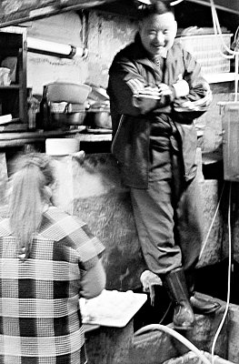 The day almost done, an old trader leans back against his basins and enjoys a bit of rest. Rubber boots and old style clothes, but this is still 2009. 

The place was so dark, fighting camera shake and motion blur was tough, even at ISO 1600 and full frame film. However, the image is so reminiscent of the old days, I  think it belongs here.