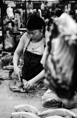 Hunks of meat lie on a table, ribs are hanging in the foreground, while a sales woman cuts a choice piece at this market in Shanghai. 

The meat is not cooled and probably not particularly well kept. This explains partly why all the meat is stir fried and cooked until well done, with more spices added the further South you go. 