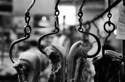 Hand smithed, iron meat hooks hold up their pieces at an old market in Shanghai. No two of these hooks and rings are alike, all are individually hammered from iron rods and only roughly finished. They seem to be done in haste by an apprentice blacksmith, but somehow strike a note of nostalgia.

I liked the broken symmetry of the image, it's raw impact.