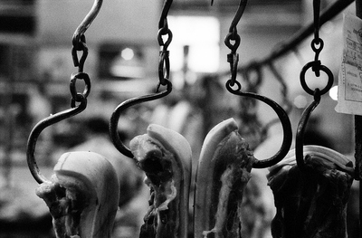 Hand smithed, iron meat hooks hold up their pieces at an old market in Shanghai. No two of these hooks and rings are alike, all are individually hammered from iron rods and only roughly finished. They seem to be done in haste by an apprentice blacksmith, but somehow strike a note of nostalgia.

I liked the broken symmetry of the image, it's raw impact.