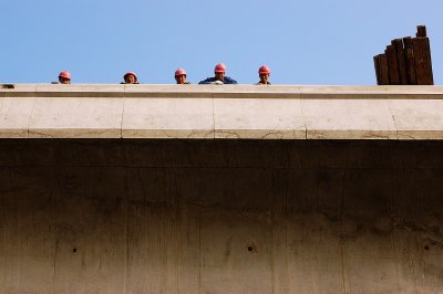 Well, there are only five, and they are not really dwarfs, but when I composed the shot, that is what they looked like. In reality, they are construction workers high up on a new piece of highway, looking down during a quick rest break.

The site near Shanghai was very accessible and people were curious and friendly as almost always.