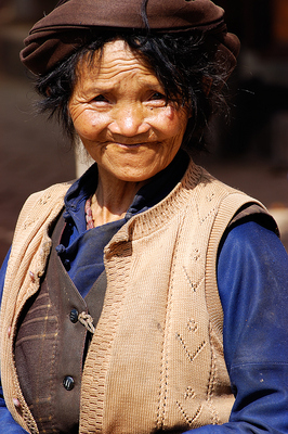 The market day was winding down and the people from the country side were packing up to go home. This lady seemed undaunted by the prospects of a long treck back home to the fields, as she smiled into the camera.

I love the unruly hair, and the face, so typical of the mountains of China.