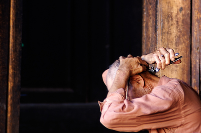 An old man is sitting on his veranda in the village of Shaxi in Yunnan, giving himself a haircut with a mechanical cutter. The light glitters on the metal of the cutter and his skin looks like the old wooden beams of the house he is living in.

I was fascinated by the posture and the light on his hand and got a couple of shots of through the open door, since I did not wish to intrude. 