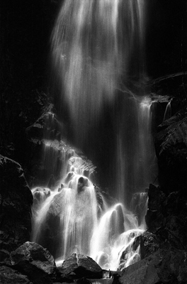 The waterfall in Cherry Valley in Yunnan is cascading down the rocks to meet the muddy brown river below.
In this black and white picture, I wanted to capture the dreamy nature of the waterfall.
Throughout the valley clear, hot springs emerge from the rocks to gather in pools. A clear spring may run right next to a surface water, flowing cold and laden with particles from the rich soil.

Shot in film, this works quite well for me.